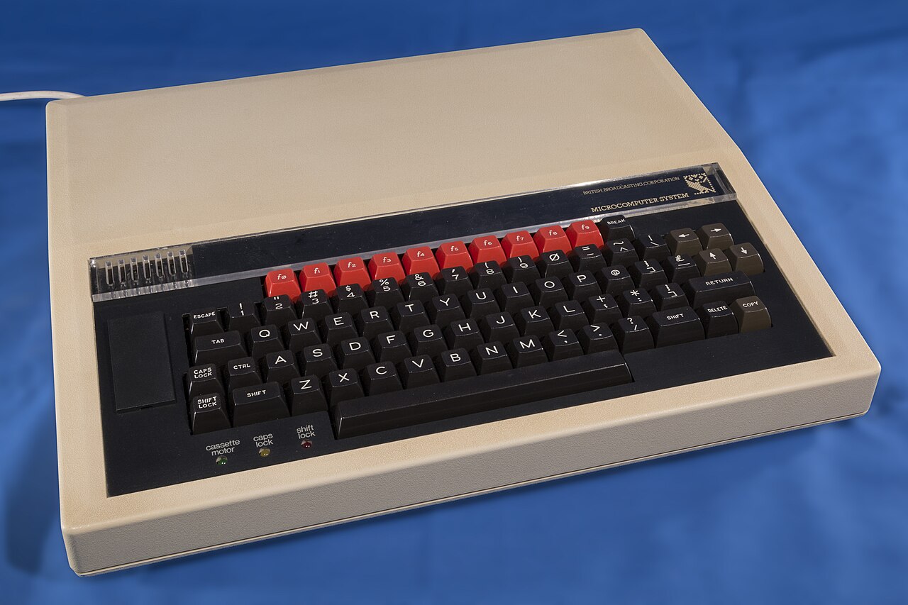 A cream-coloured Acorn BBC Micro Model B computer with its black keyboard and red function keys
