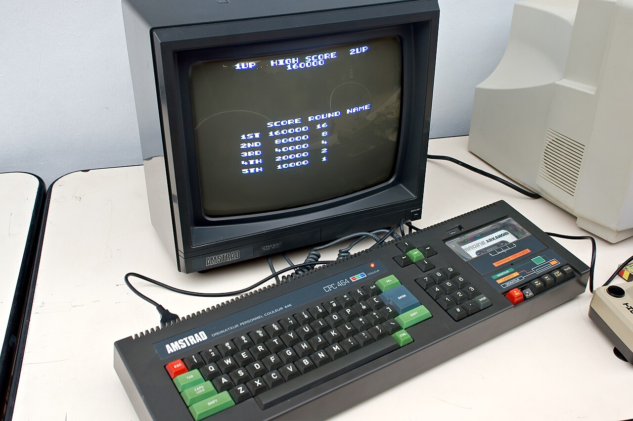 An Amstrad CPC 464 computer with its built-in cassette deck, sitting in front of an Amstrad CTM640 colour monitor