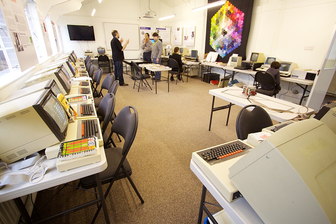 A recreated school computer room with rows of BBC Micro computers and monitors on desks